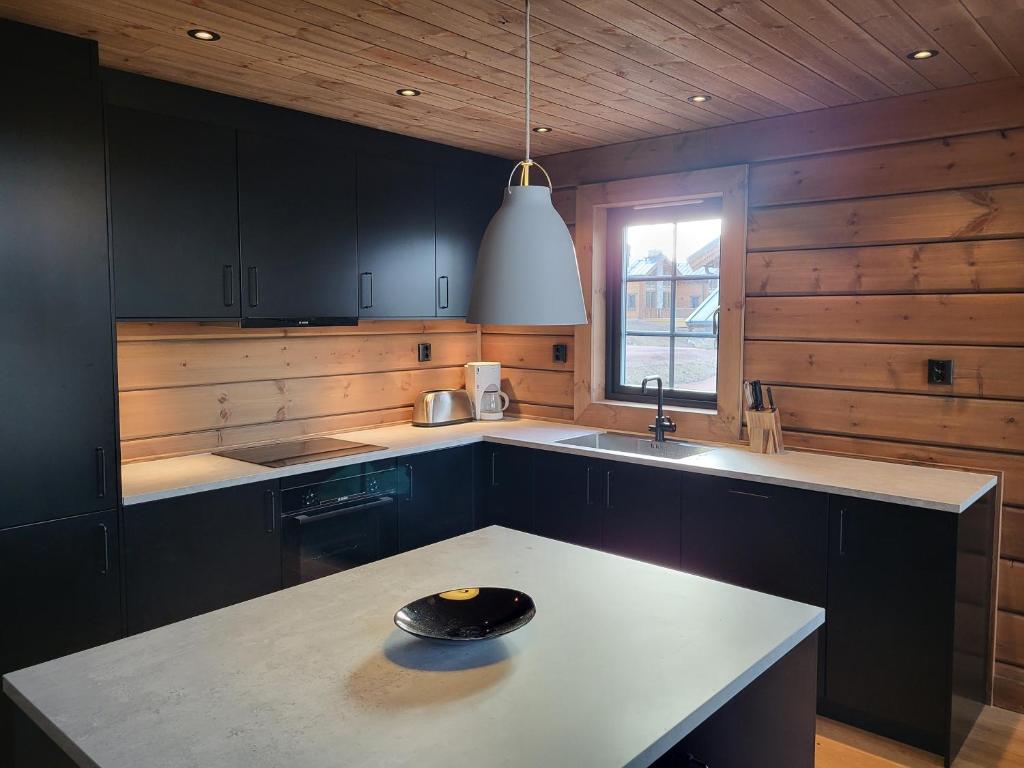 a kitchen with black cabinets and a white counter top at Idre Mountain Lodge in Idre