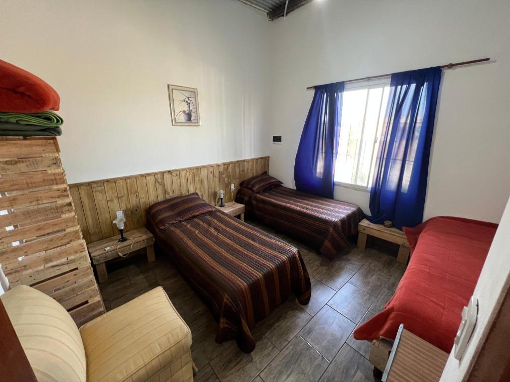 sala de estar con 2 camas y ventana en Puesta del Sol en Campo Quijano