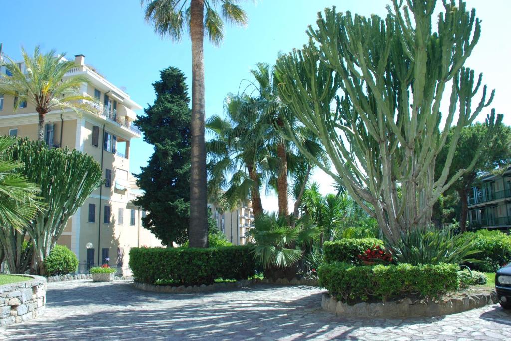 ein Resort mit Palmen und einem Gebäude in der Unterkunft Giardino del Mare in Bordighera