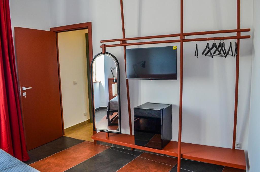 Cette chambre comprend un miroir et une télévision. dans l'établissement Scavi 32, à Ercolano