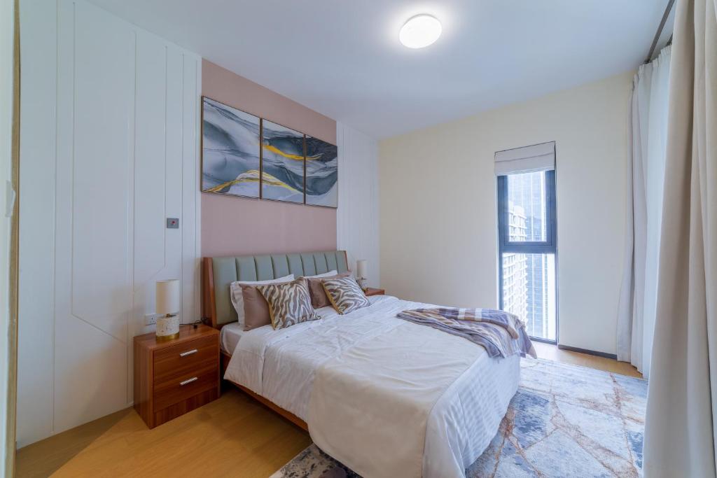 a white bedroom with a bed and a window at GTC Luxury Top Floor Apartment, Nairobi in Nairobi