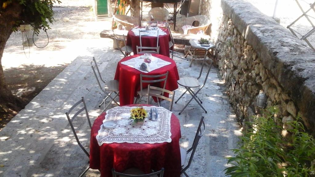 a group of tables and chairs with red table cloths at Sotto il carrubo in Sciacca