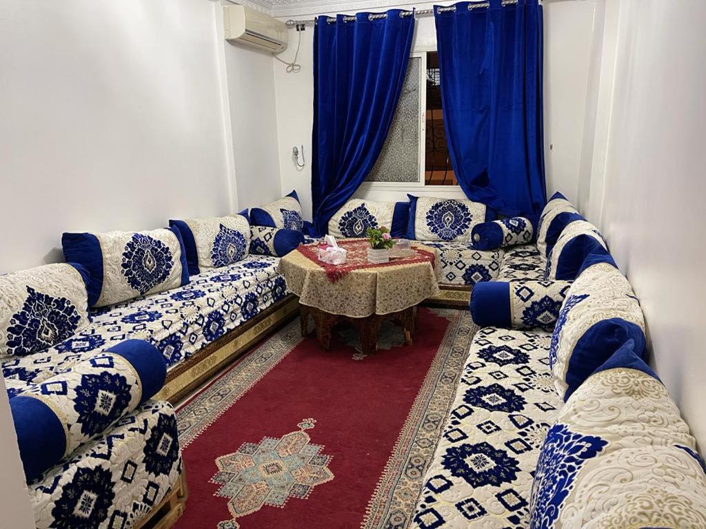 een woonkamer met blauwe en witte banken en een tafel bij Centre Sala Al Jadida in Oulad Yakoub