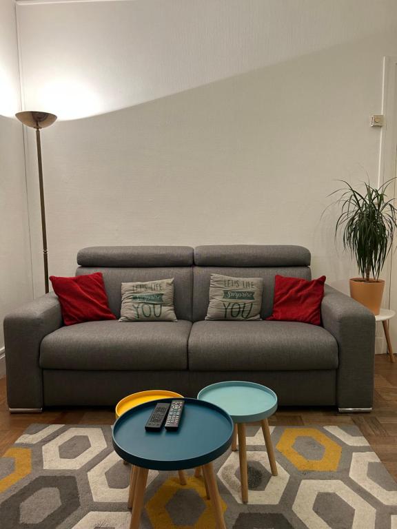 un salon avec un canapé et deux tables dans l'établissement Le Rockefeller, à Lyon