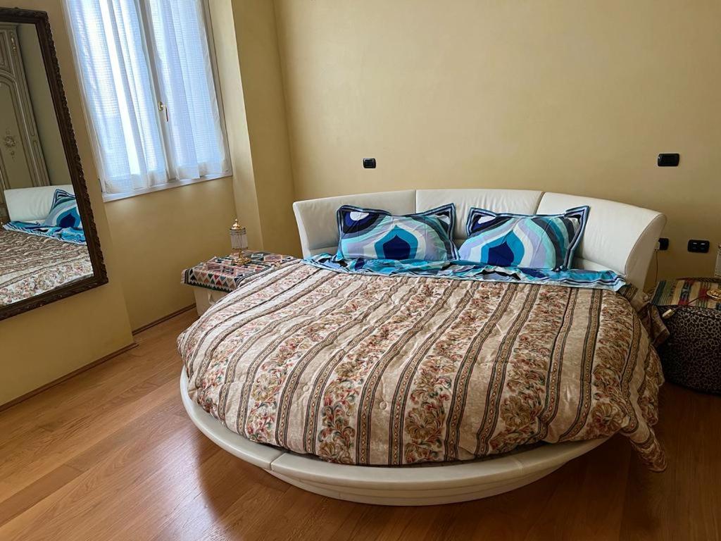 sypialnia z dużym łóżkiem z niebieskimi poduszkami w obiekcie The Green House w mieście Busseto
