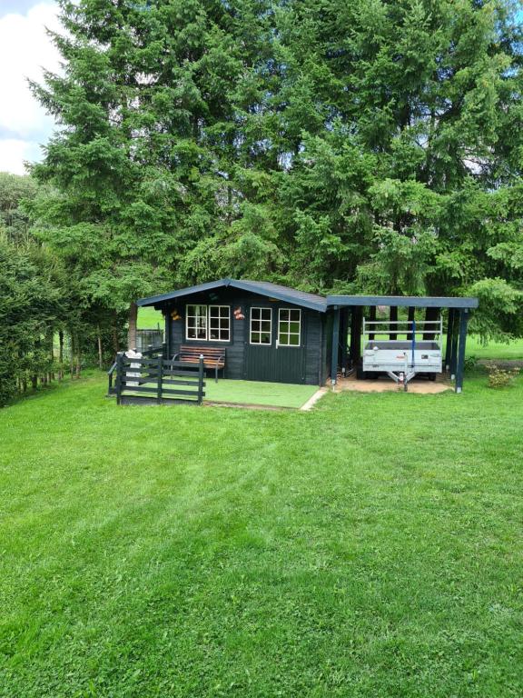 a small shed in the middle of a grass field at Trekkershut in Wallenborn