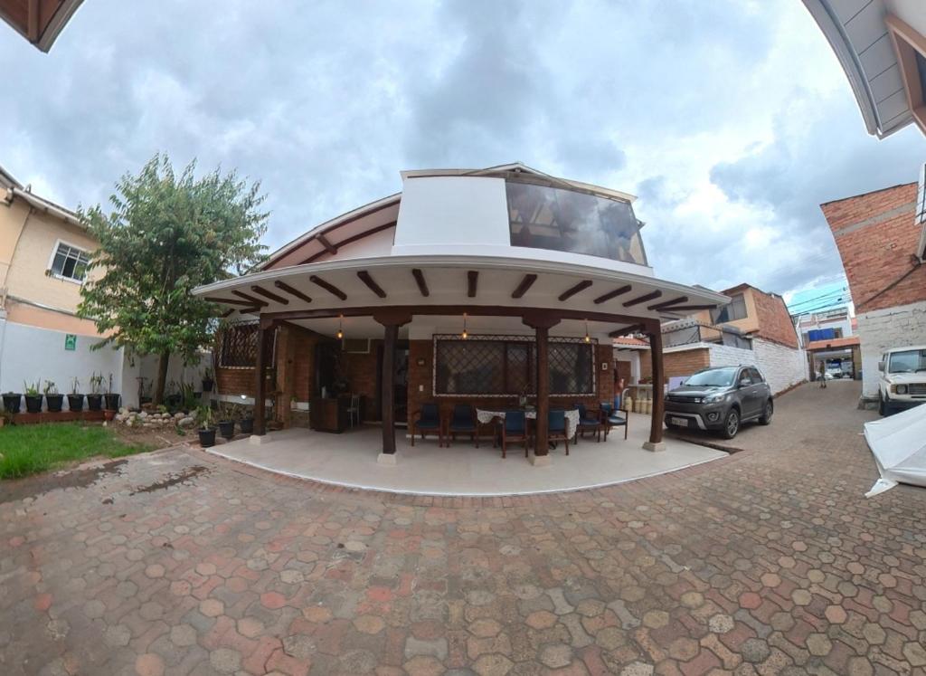a pavilion with a table and chairs in a parking lot at Estancia el Capulí in Cuenca