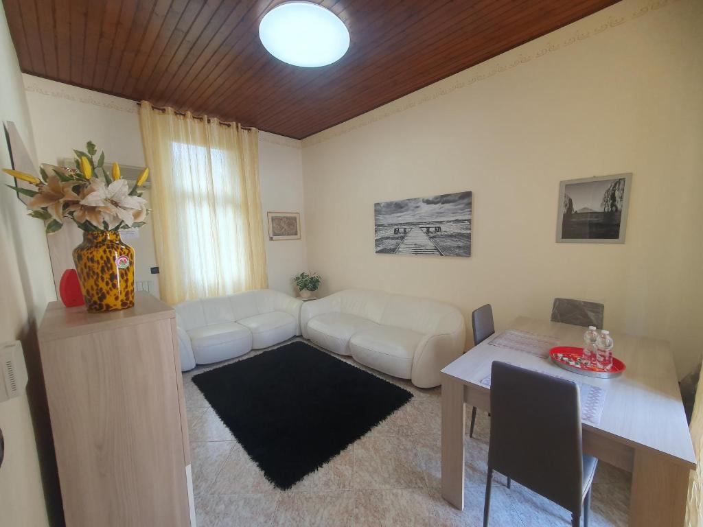een woonkamer met een witte bank en een tafel bij Henson appartamento in Tortona