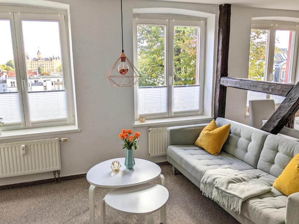 - un salon avec un canapé et une table dans l'établissement Schlossblick - Modernes & zentrales Apartment mit Balkon und Arbeitsplatz, à Schwerin