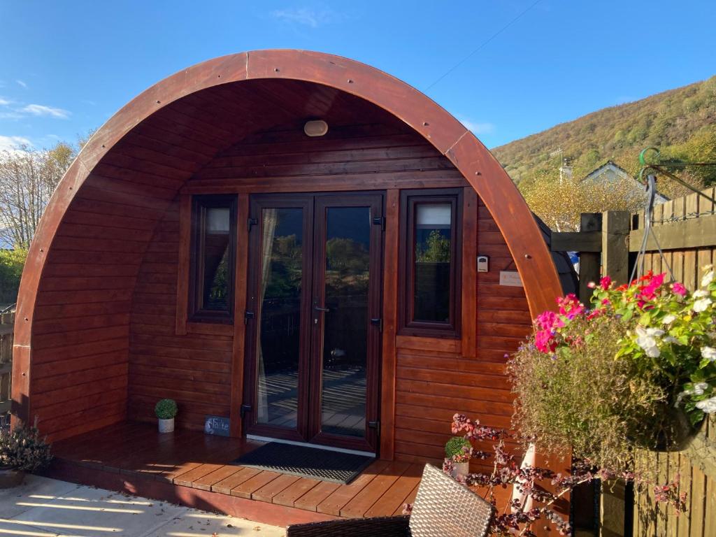 an arched entry way to a wooden hobbit house at The Fox's Den, Luxury Cosy Mini Lodge, Highlands in North Ballachulish