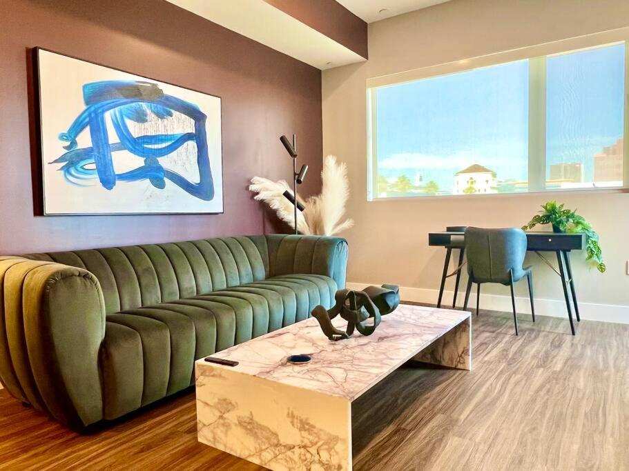 a living room with a green couch and a table at Designer Hollywood Penthouse with Private Balcony on Sunset in Los Angeles