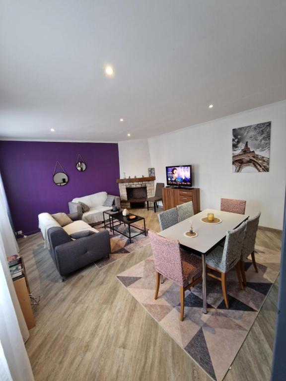 a living room with a couch and a table at duplex spacieux Jo24 proche Paris et stade de France in Drancy