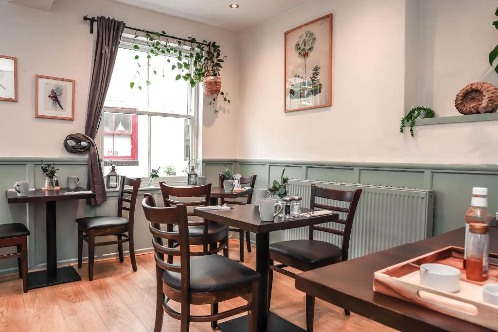 a dining room with tables and chairs and a window at Endeavour, Staithes in Staithes