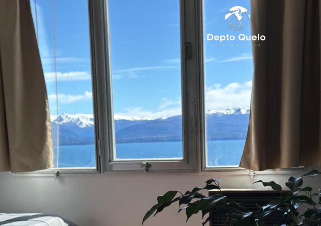 a window with a view of snow capped mountains at Depto. Quelo in San Carlos de Bariloche