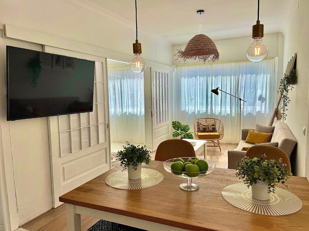 a living room with a table and a television at Las Brisas 2 by SunHousesCanarias in Las Palmas de Gran Canaria