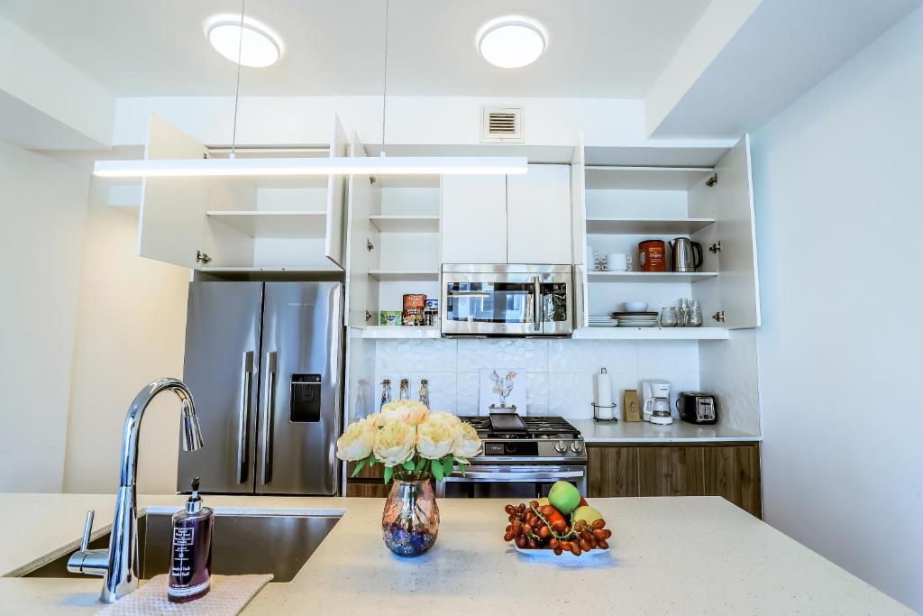 a kitchen with a stainless steel refrigerator and a sink at Vibrant & Modern Loft-style Walkout Near LRT in Calgary