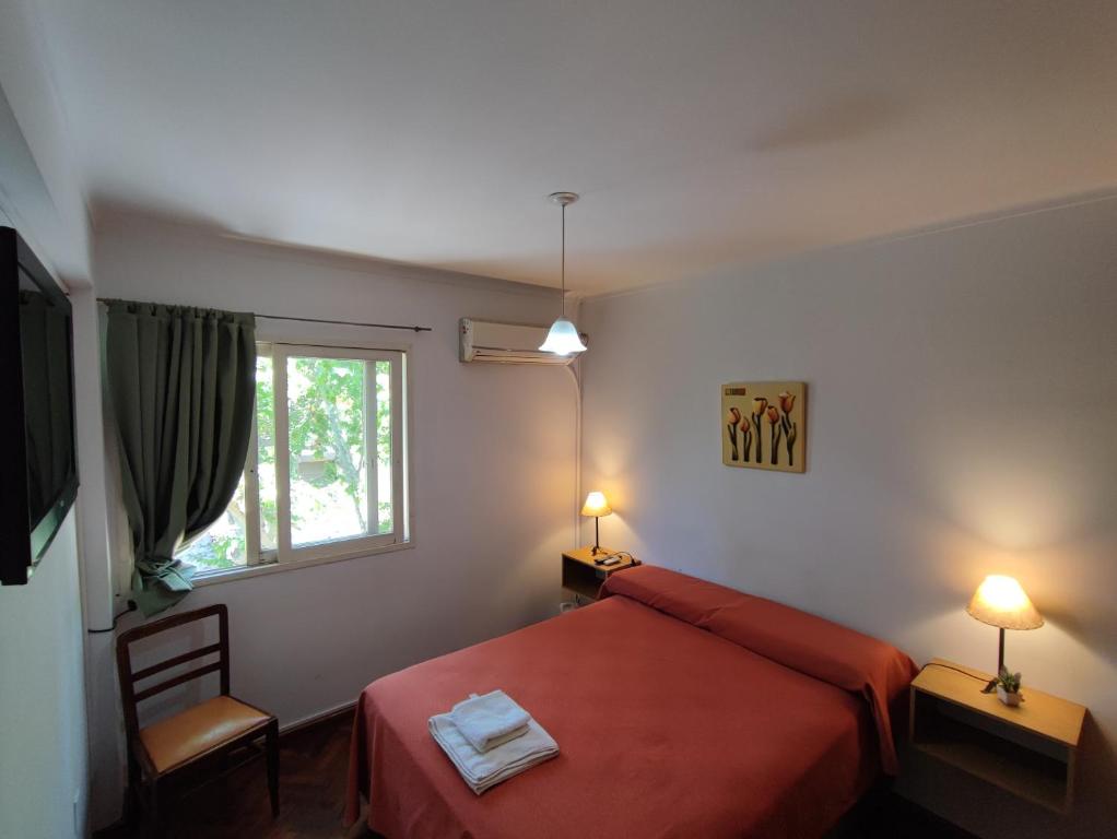 1 dormitorio con cama roja y ventana en Bonarda II en Mendoza