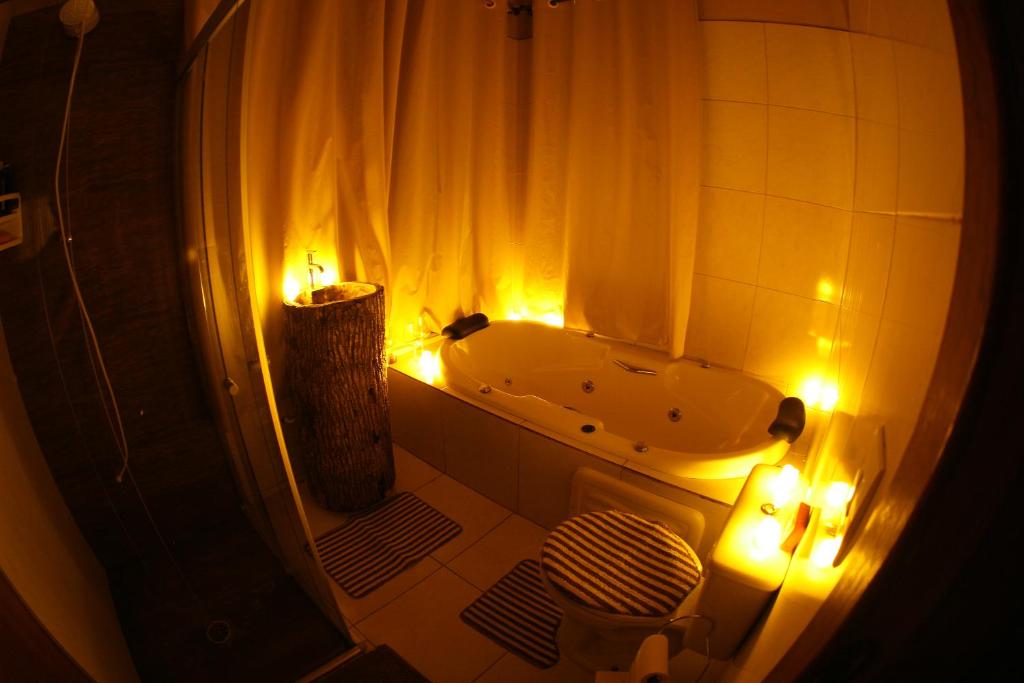 baño con bañera, aseo y luces en Cabana Refúgio da Mata en Juquitiba