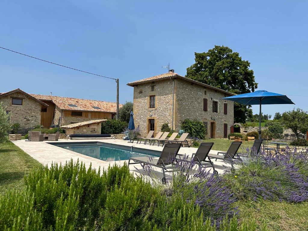 ein Pool mit Stühlen und einem Sonnenschirm und ein Haus in der Unterkunft Gites&chambres d hôtes Les granges du Fournel in Saint-Lattier