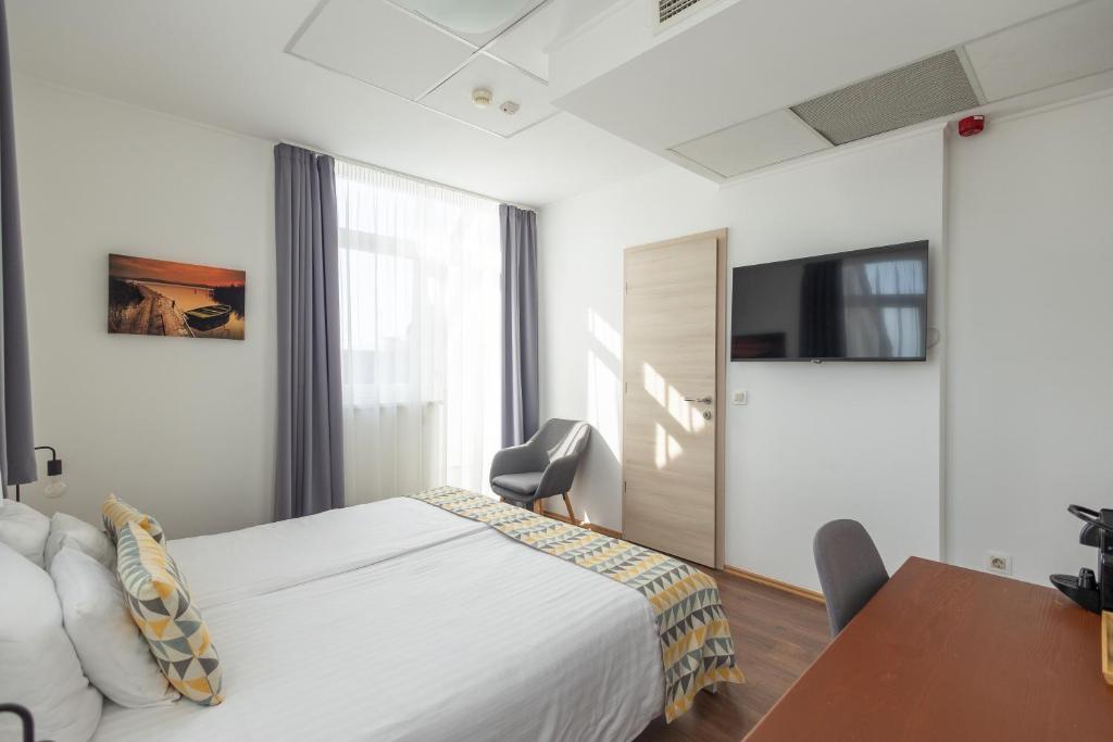 um quarto com uma cama, uma mesa e uma cadeira em Rooftop City Residence em Budapeste