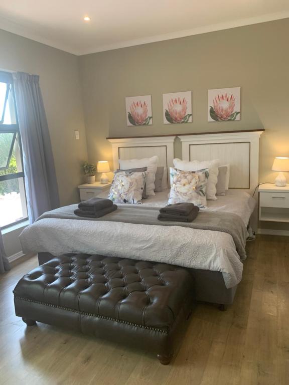 a bedroom with a large bed with a leather ottoman at Langebaan Golf Studio B1 - Langebaan Golf Estate in Langebaan