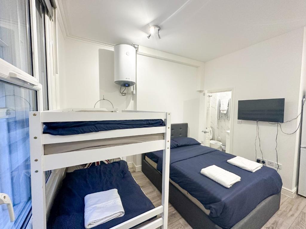 a bedroom with two bunk beds and a tv at Flat 6 in Croydon