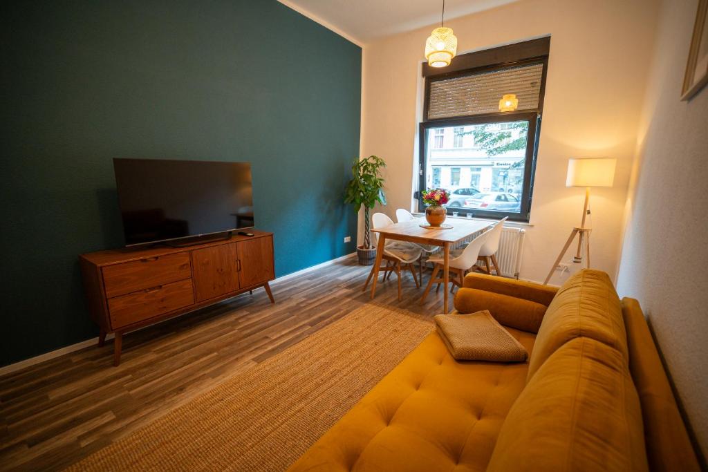 a living room with a couch and a tv and a table at RR - Spacious Apartments - Central - Parking in Magdeburg