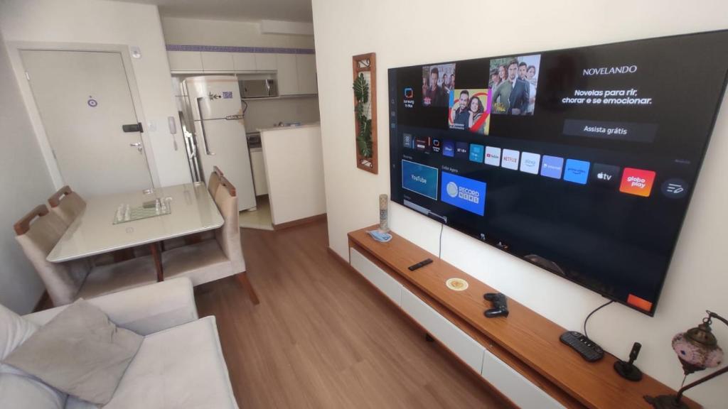 a living room with a large flat screen tv at Apartamento Novinho Aeroporto JF in Juiz de Fora