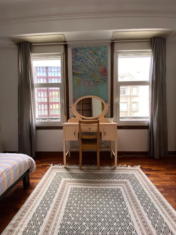 a dressing table and mirror in a room with windows at Habitación Céntrica in A Coruña