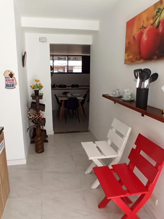 uma sala de estar com cadeiras vermelhas e uma mesa em Casa Laureles - San Joaquín em Medellín