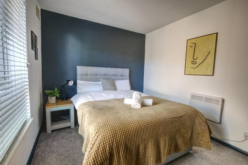 a bedroom with a bed with a yellow blanket at #2 Limes by DerBnB, Modern 1 Bedroom Apartment, Free Parking, WI-FI & Netflix Near Royal Derby Hospital in Derby