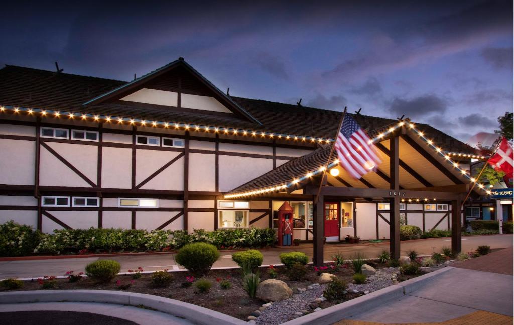 a building with lights and two american flags on it at King Frederik Inn in Solvang