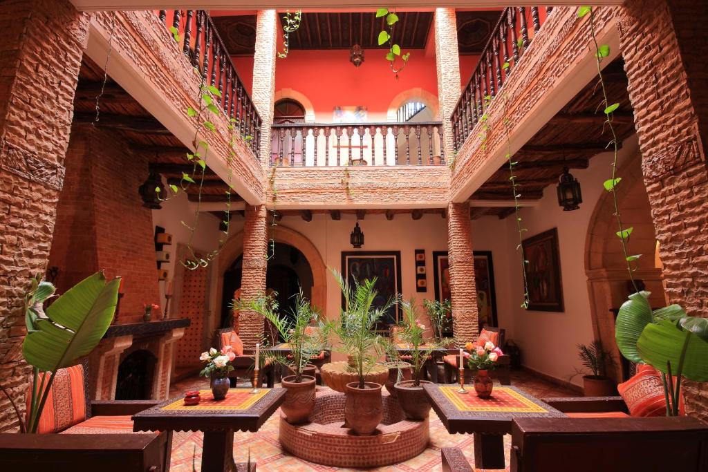 a courtyard with tables and plants in a building at Riad Maison Du Sud in Essaouira