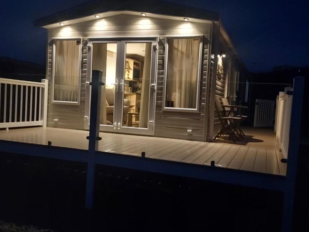 a tiny house with a deck at night at Luxury caravan in Morecambe