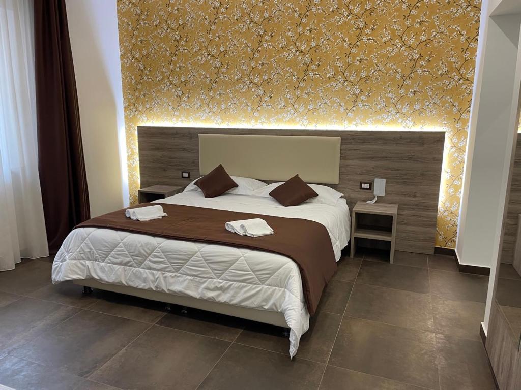 ein Schlafzimmer mit einem großen Bett mit einer goldenen Wand in der Unterkunft B&B La Villa Cittanova in Cittanova