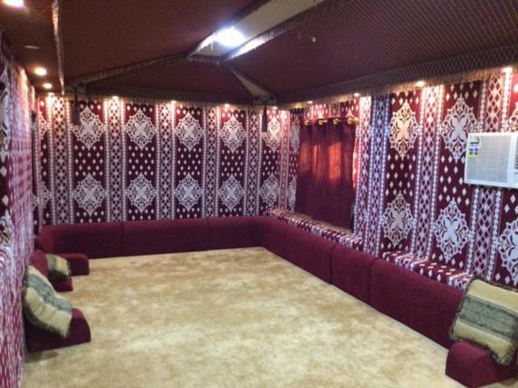 uma sala de estar com um sofá vermelho e cortinas em نزل ريفي ( شاليه زراعي ) 