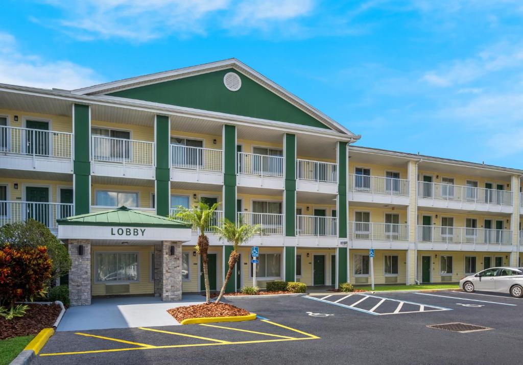 an exterior view of a hotel with a parking lot at HomeTowne Studios by Red Roof Orlando - UCF Area in Orlando