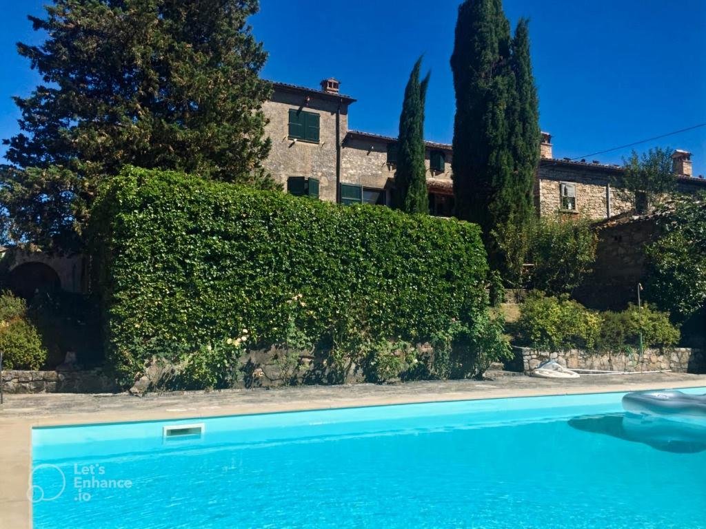 a house with a hedge and a swimming pool at Casa Dinda in Città di Castello