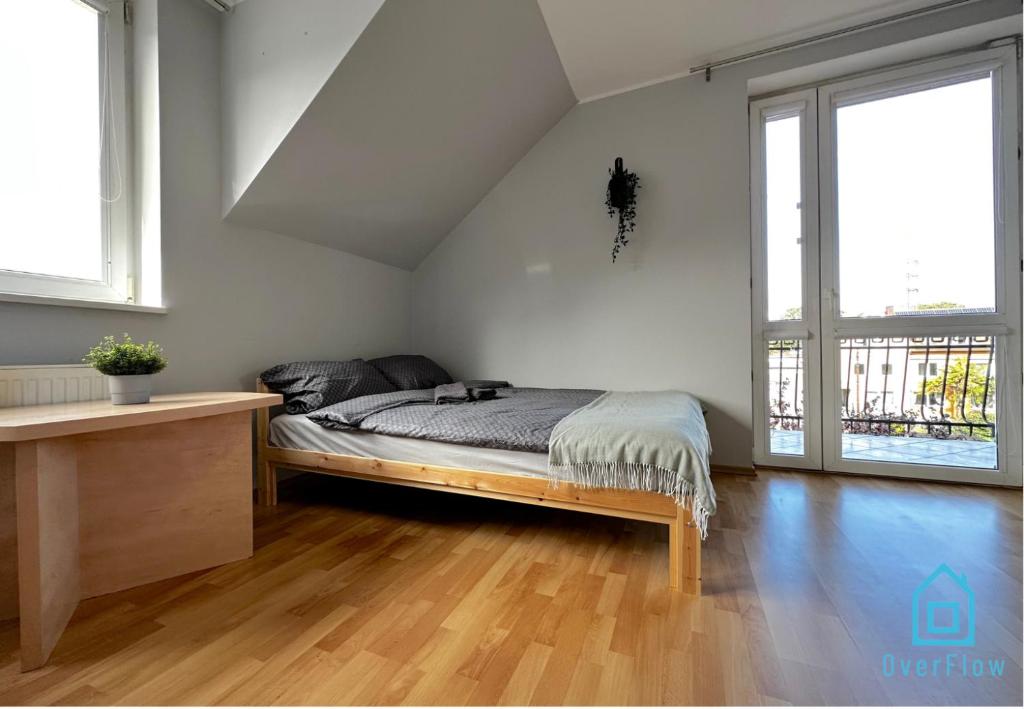 a bedroom with a bed and two large windows at Mickle Room in Gdańsk