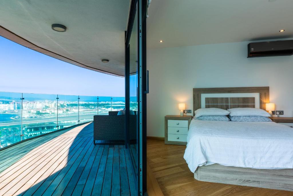 a bedroom with a bed and a balcony with a view at OCEAN Plaza Suite 07-Hosted by Sweetstay in Gibraltar