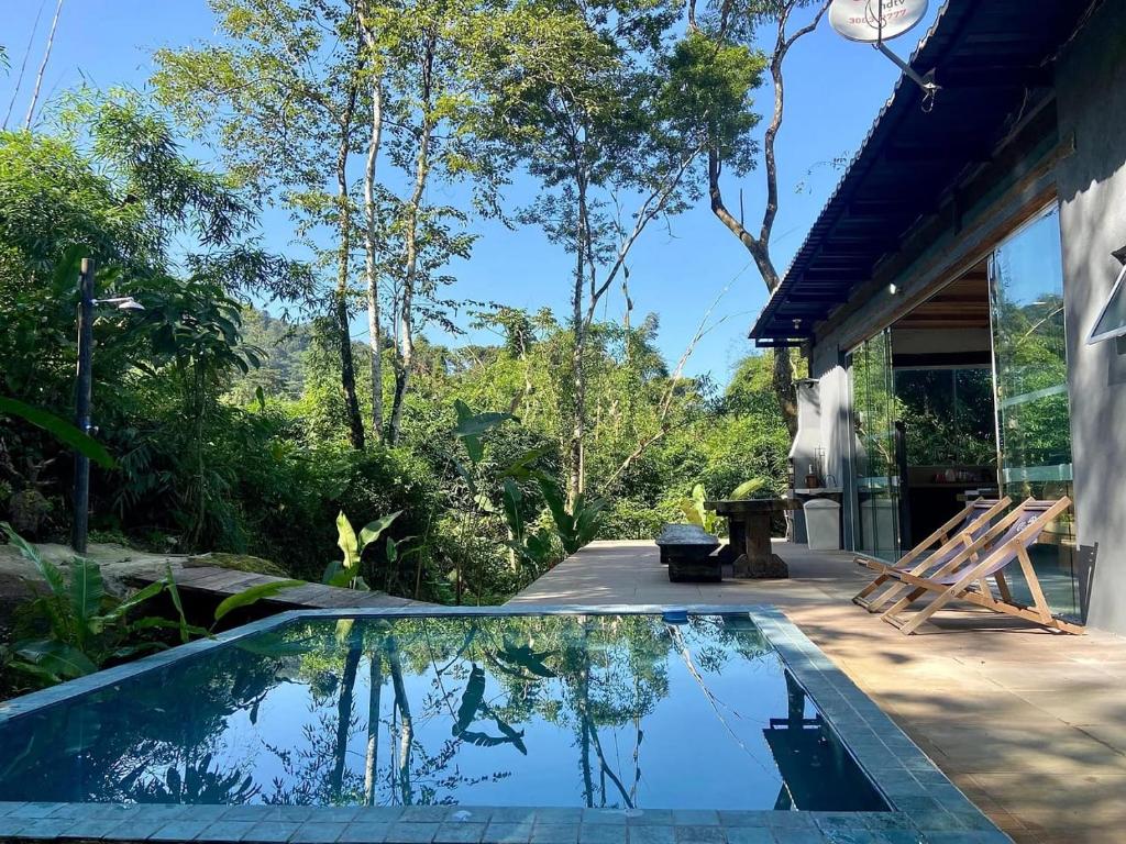 uma piscina no quintal de uma casa em CASA DE VIDRO COM VISTA PARA O MAR em São Sebastião