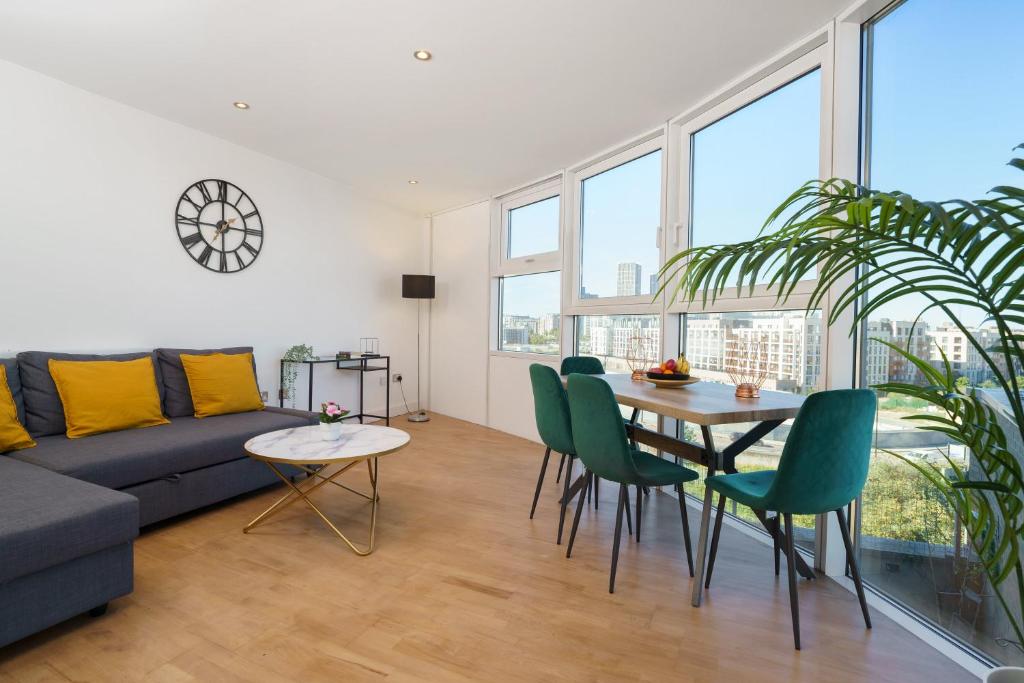 een woonkamer met een bank en een tafel en stoelen bij Attractive London Apartment in Londen