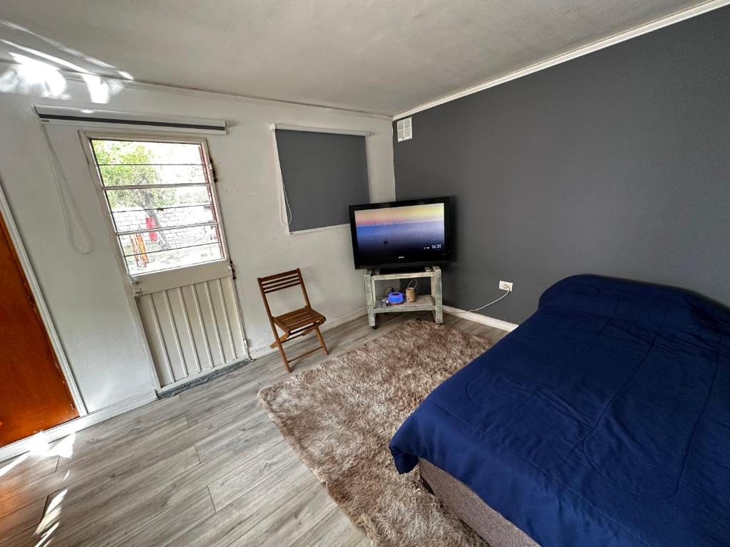 a bedroom with a bed and a flat screen tv at San Miguel departamentos in Trelew