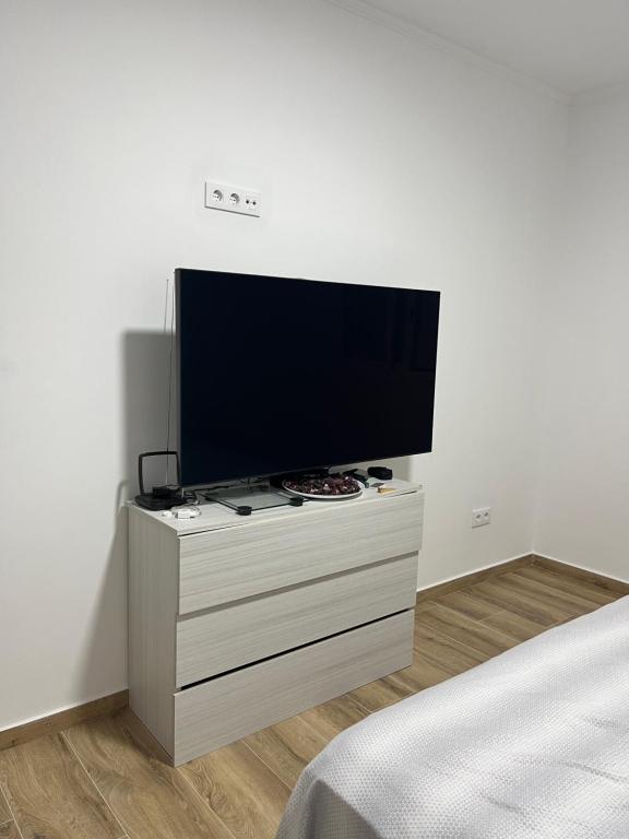 einen Flachbild-TV auf einer Kommode in einem Schlafzimmer in der Unterkunft Apartamentos La Meridian in Barcelona