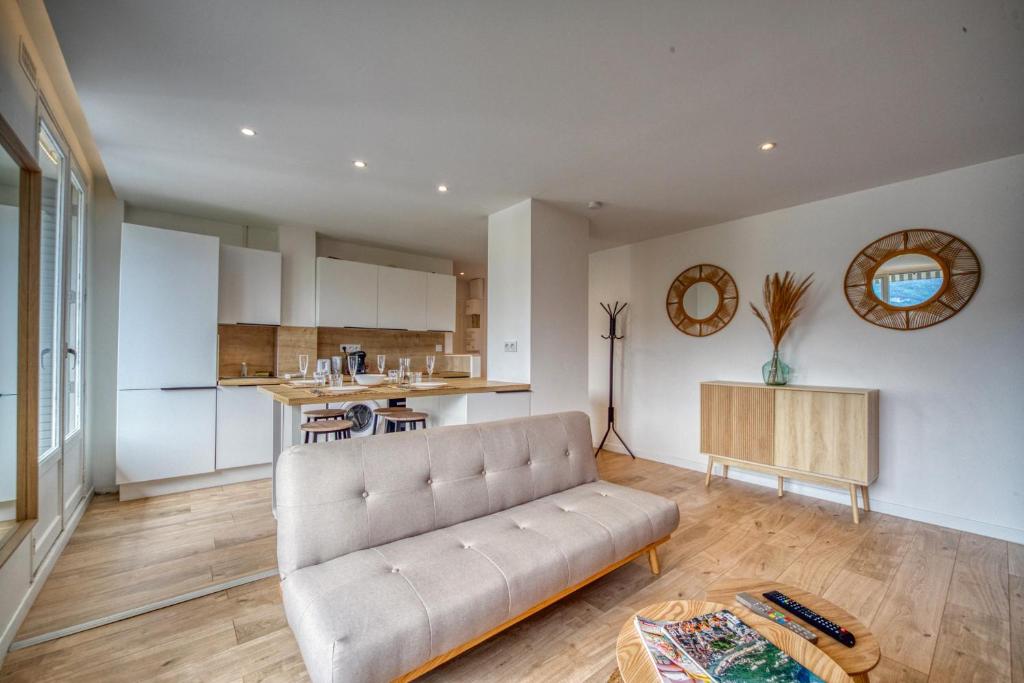 uma sala de estar com um sofá e uma cozinha em Le Lyon - Bastille / Esplanade em Grenoble