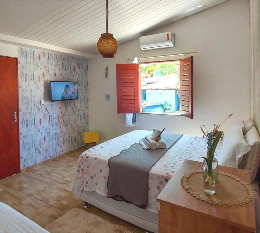 um quarto com uma cama, uma janela e uma mesa em Na Casa Delas Jeri - com Churrasqueira em Jericoacoara