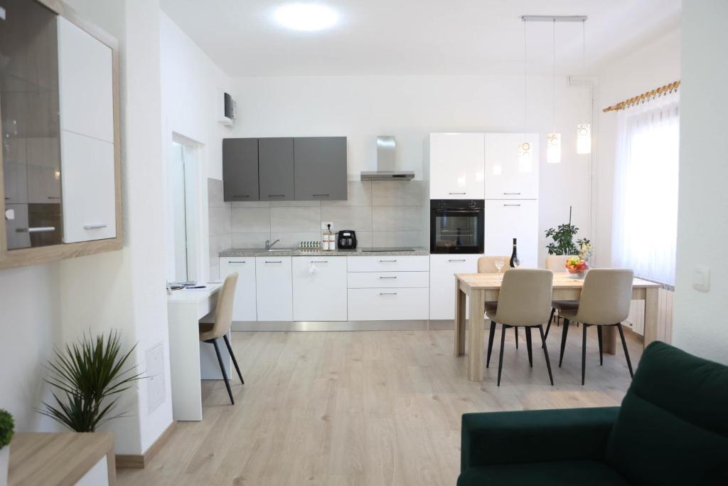 a kitchen and dining room with a table and chairs at Apartman Tip Top in Gospić
