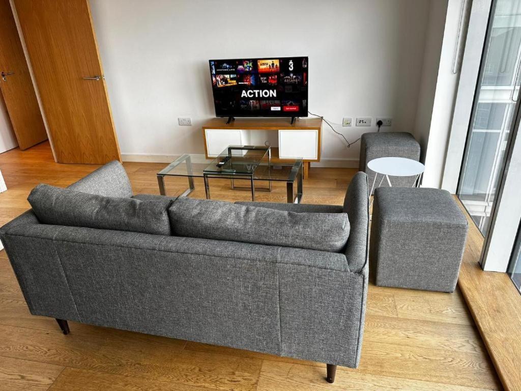 a living room with a couch and a tv at lovely one bedroom apartment in Ilford town in Ilford