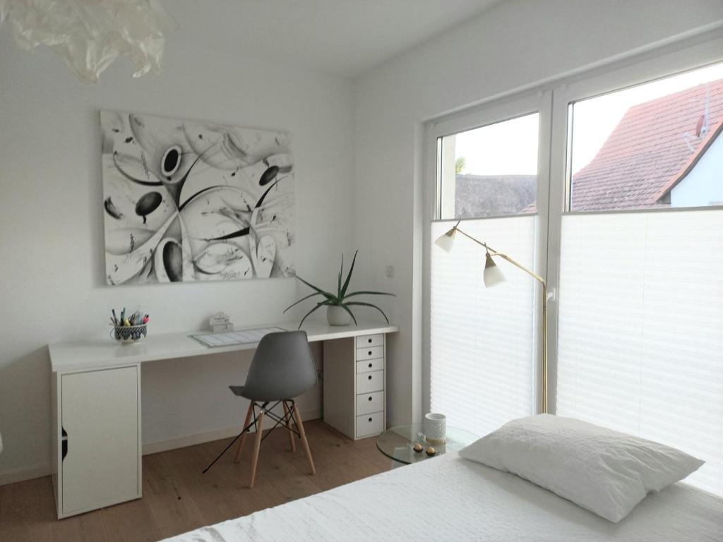 a bedroom with a bed and a desk and a window at Privates Zimmer mit Bad in Efringen-Kirchen