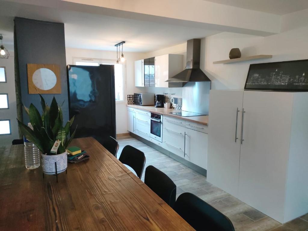 eine Küche mit einem Holztisch und einem Kühlschrank in der Unterkunft Maison 10 couchages secteur Fontainebleau in Vernou-sur-Seine